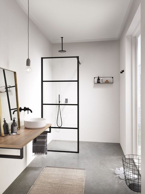 A-minimalist-bathroom-with-neutral-walls-a-concrete-floor-a-simple-vanity-a-mirror-and-a-pendant-bulb