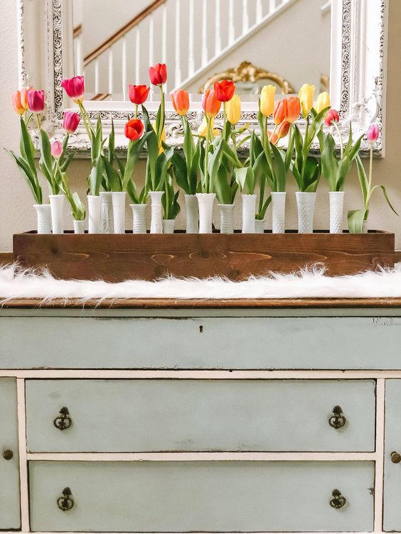 A-wooden-box-white-textural-vases-and-a-whole-arrangement-of-bright-spring-tulips-is-a-bold-decoration-for-spring
